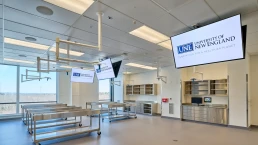 Image of a large open room with steel rolling tables, bright lighting, large windows, and steel cabinets.