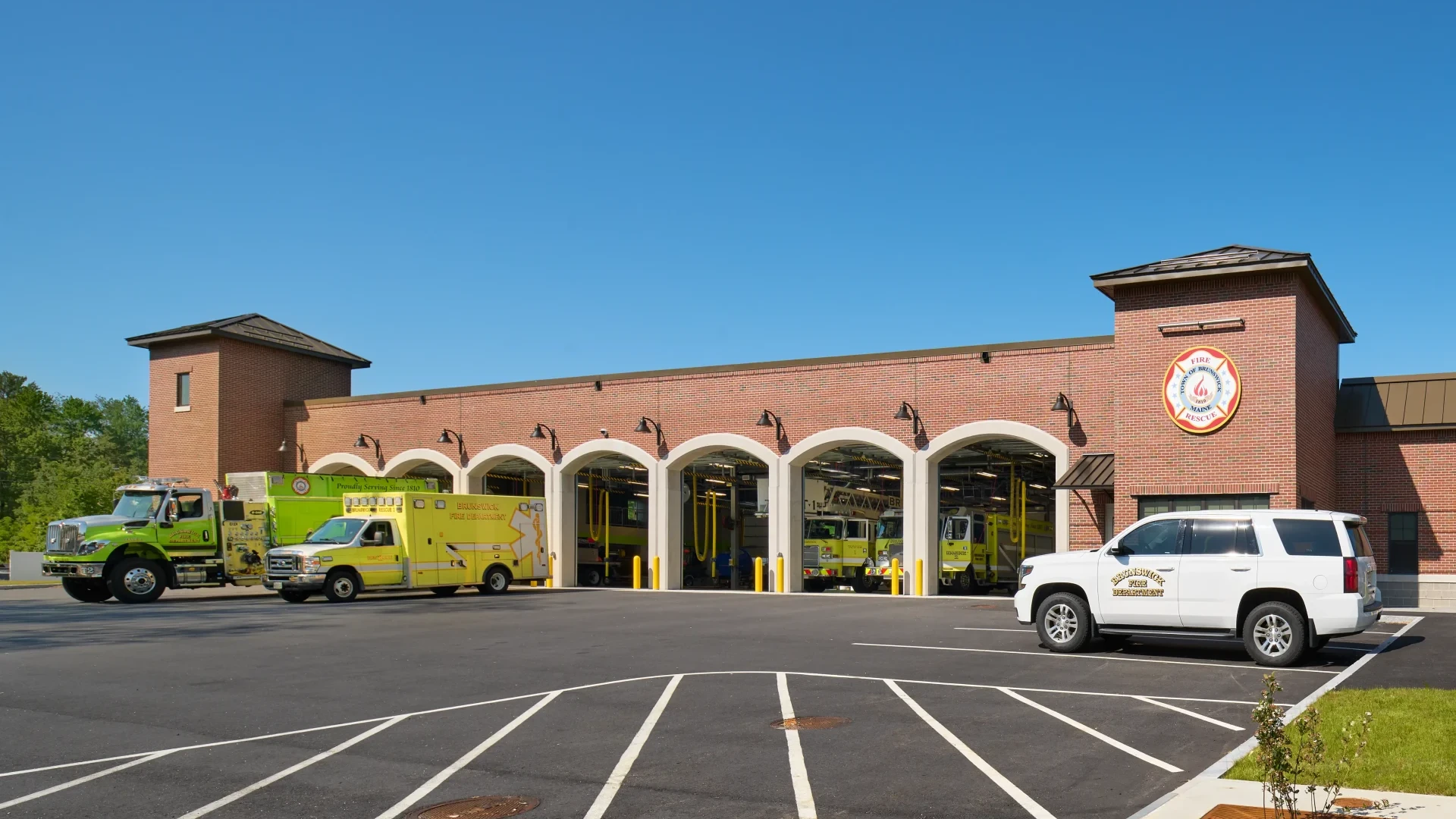 Exterior view of the Brunswick Fire Station, showcasing its brick facade and large equipment bays with fire trucks visible.