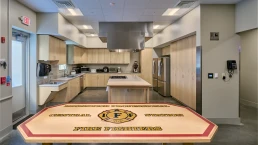 Modern kitchen area inside the Brunswick Fire Station, featuring a large island and fire department-themed table.