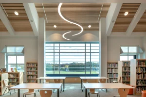 The library with a large window and wood accents adds a soothing tone to the room.