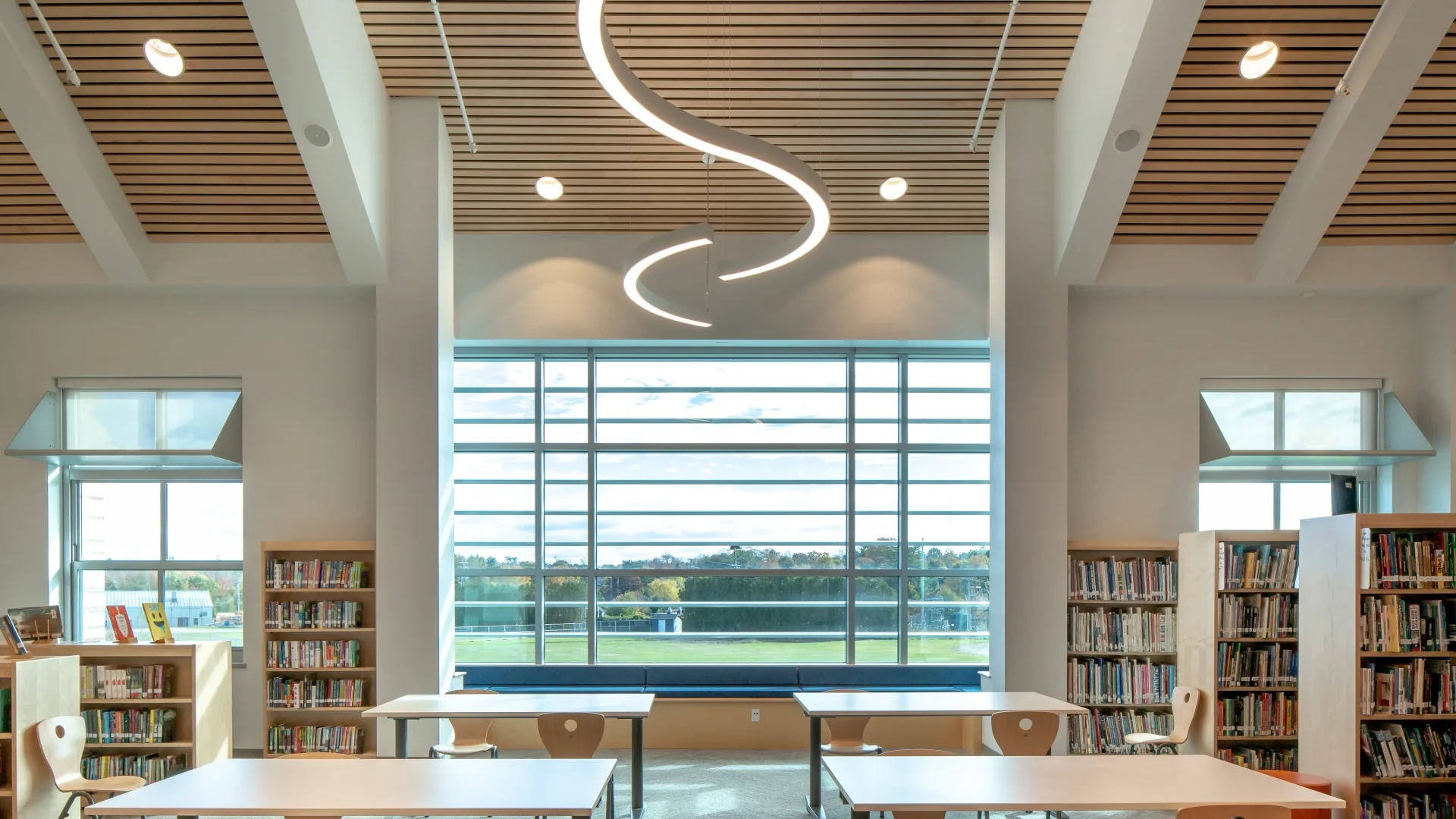 The library with a large window and wood accents adds a soothing tone to the room.