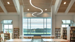 The library with a large window and wood accents adds a soothing tone to the room.