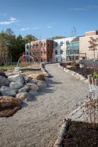 Camden-Rockport Middle School exterior shot of the playground and gravel walkway to school